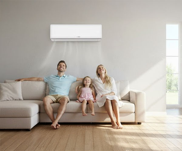 Szczęśliwa rodzina spędzająca czas w komfortowo klimatyzowanym salonie dzięki cichej i wydajnej klimatyzacji Brisse, zapewniającej idealną temperaturę.